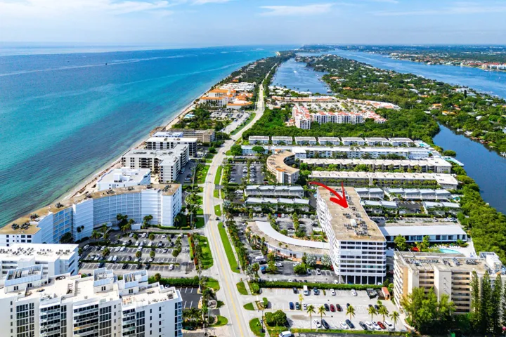 Coastal property with a prominent white multi-story building perfectly located between Ocean and Intercoastal waters.