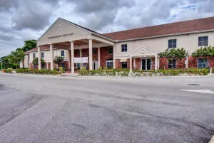 Two-story commercial building featuring a prominent gabled portico entrance with multiple columns