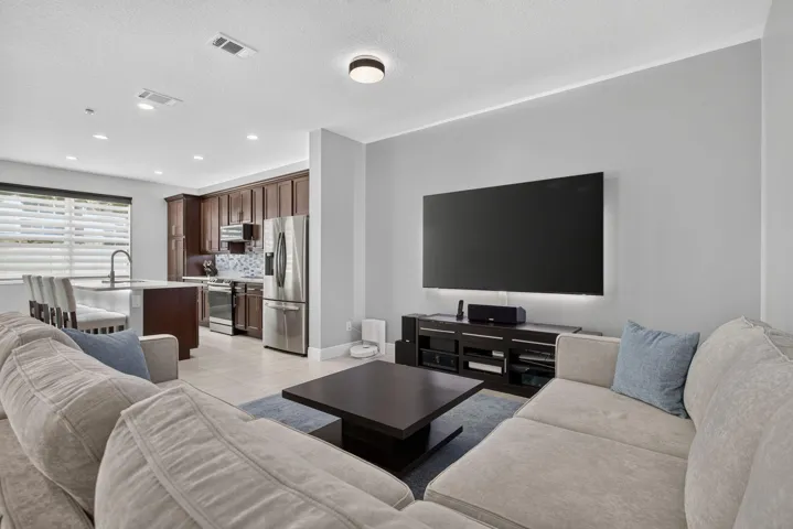 Open-concept living area featuring light gray walls, recessed lighting, and tile flooring