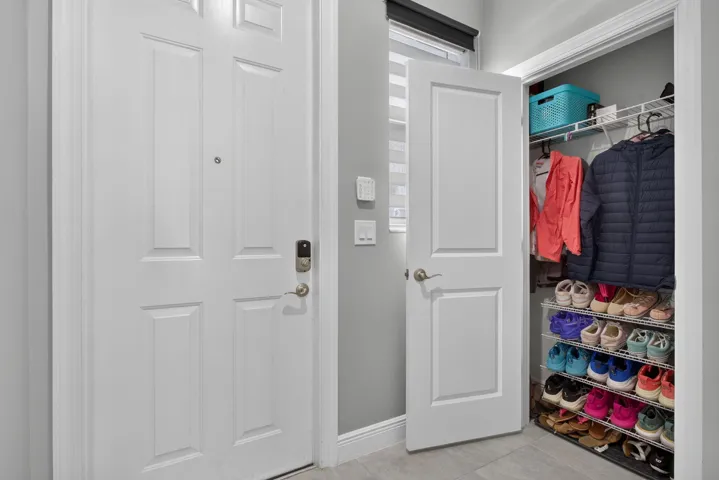 Entryway featuring a paneled door with smart lock hardware, a secondary paneled door, and a closet with wire shelving