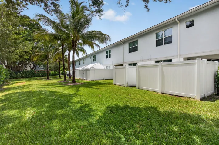 Expansive green lawn bordering a row of palm trees