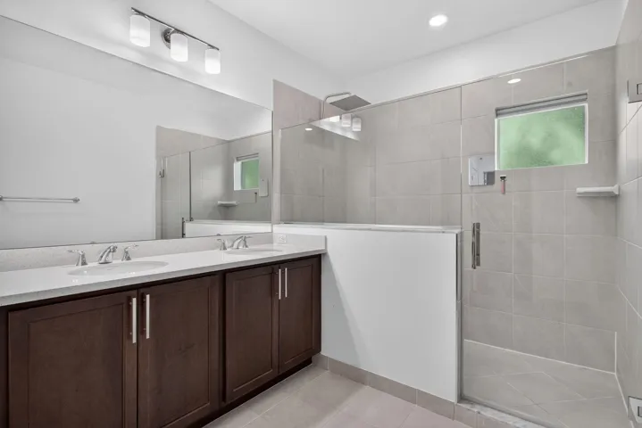 Dual sink vanity with dark wood-finish cabinetry and light-toned countertop