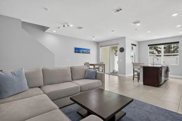 Spacious open-concept living area featuring light gray walls and recessed lighting