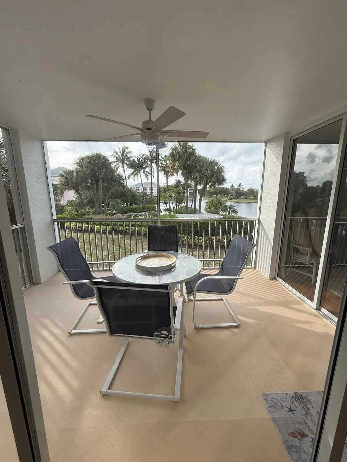 Expansive covered balcony featuring a ceiling fan, light-toned flooring, and sliding glass doors