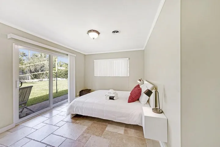 Sliding glass doors opening to a grass yard with paver patio