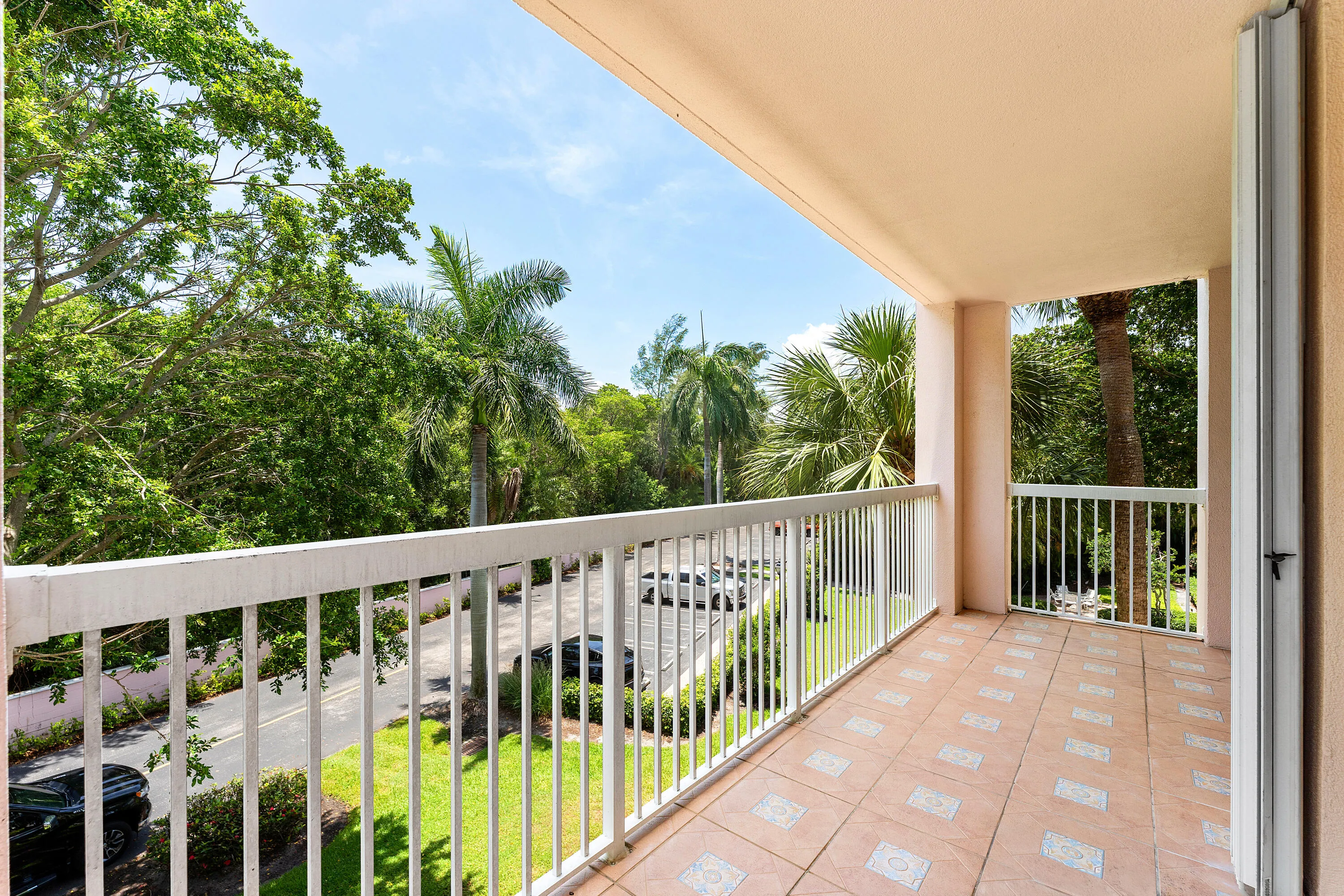 Covered balcony featuring tile flooring and a white metal railing
