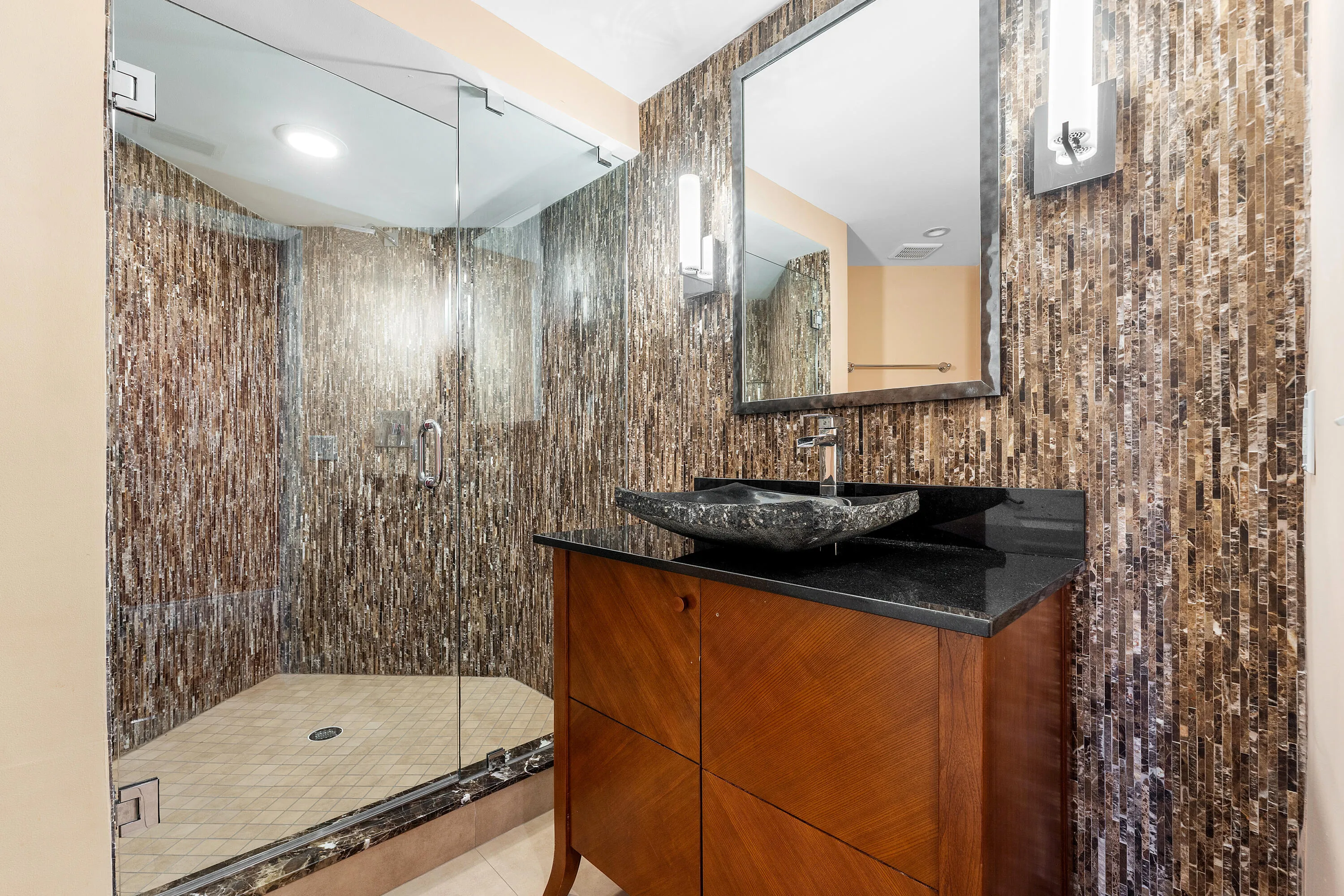 Full-height glass shower enclosure with patterned tile surround