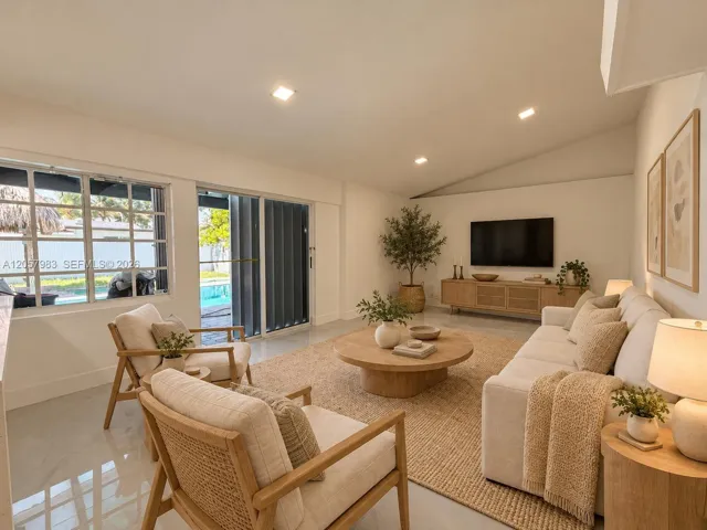 Spacious living area featuring a vaulted ceiling and recessed lighting