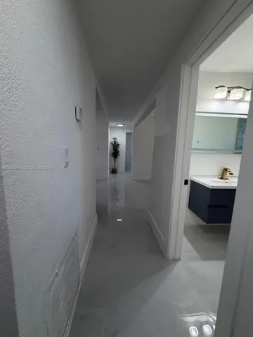 Polished large-format tile flooring extending through the hallway