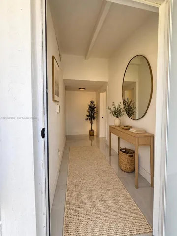 Recessed lighting throughout, exposed ceiling beam, and light-toned flooring