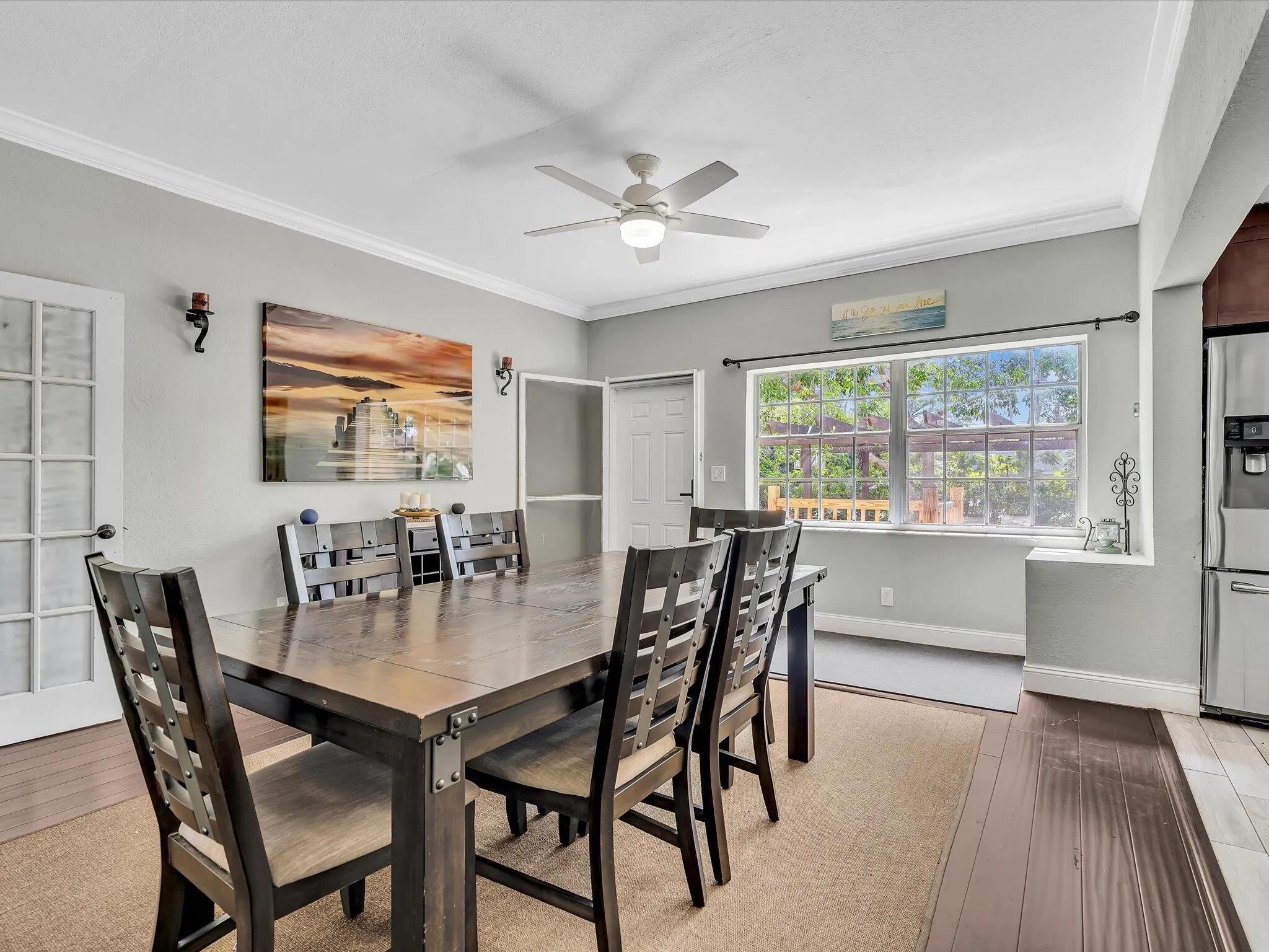 Formal dining area featuring a ceiling fan, crown molding, and a large window with natural light