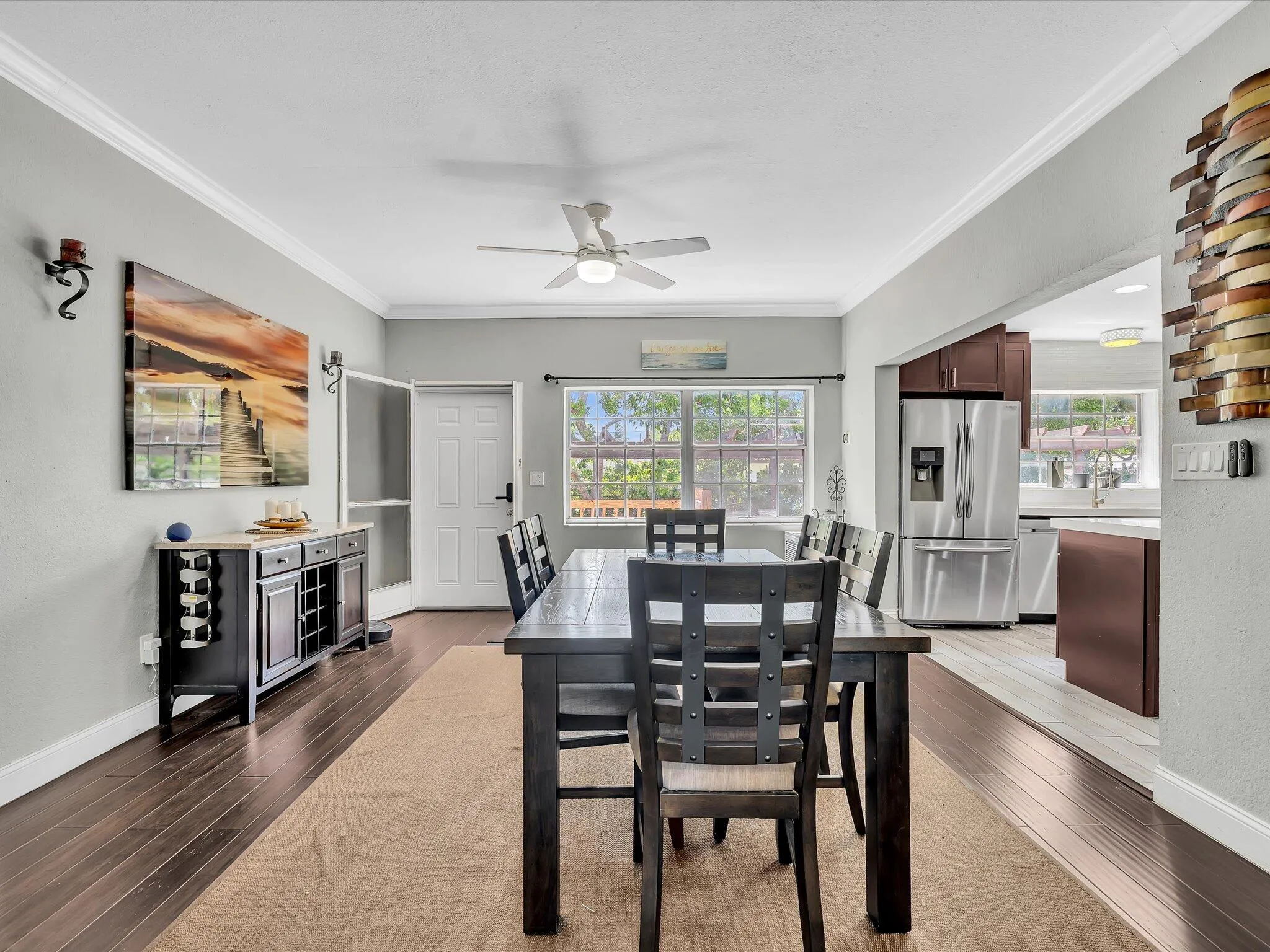 Dining area featuring wood-finish flooring, a ceiling fan, and crown molding