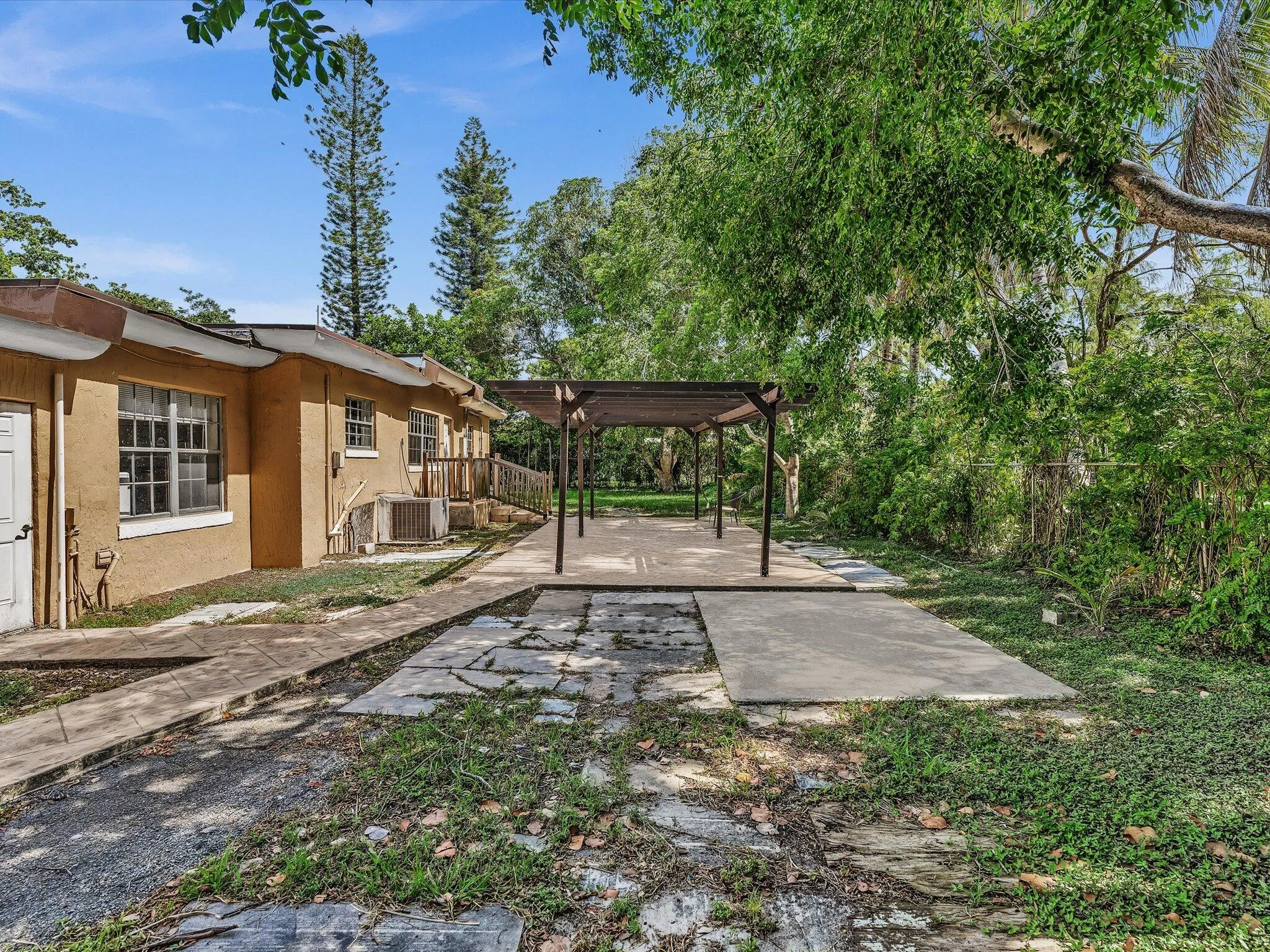 Spacious exterior patio featuring a wooden pergola