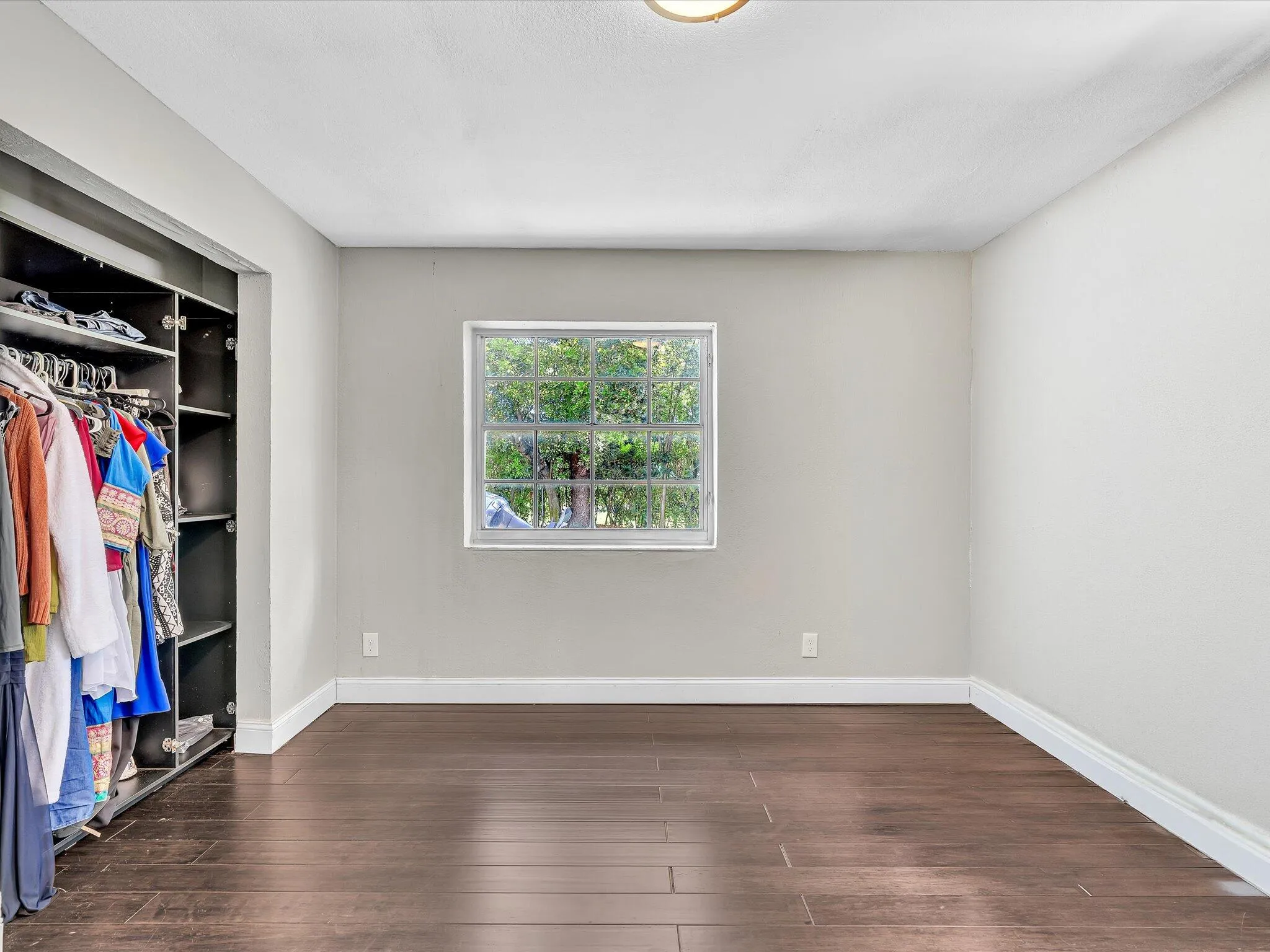 Recessed custom closet system, wood-finish flooring, and white baseboards