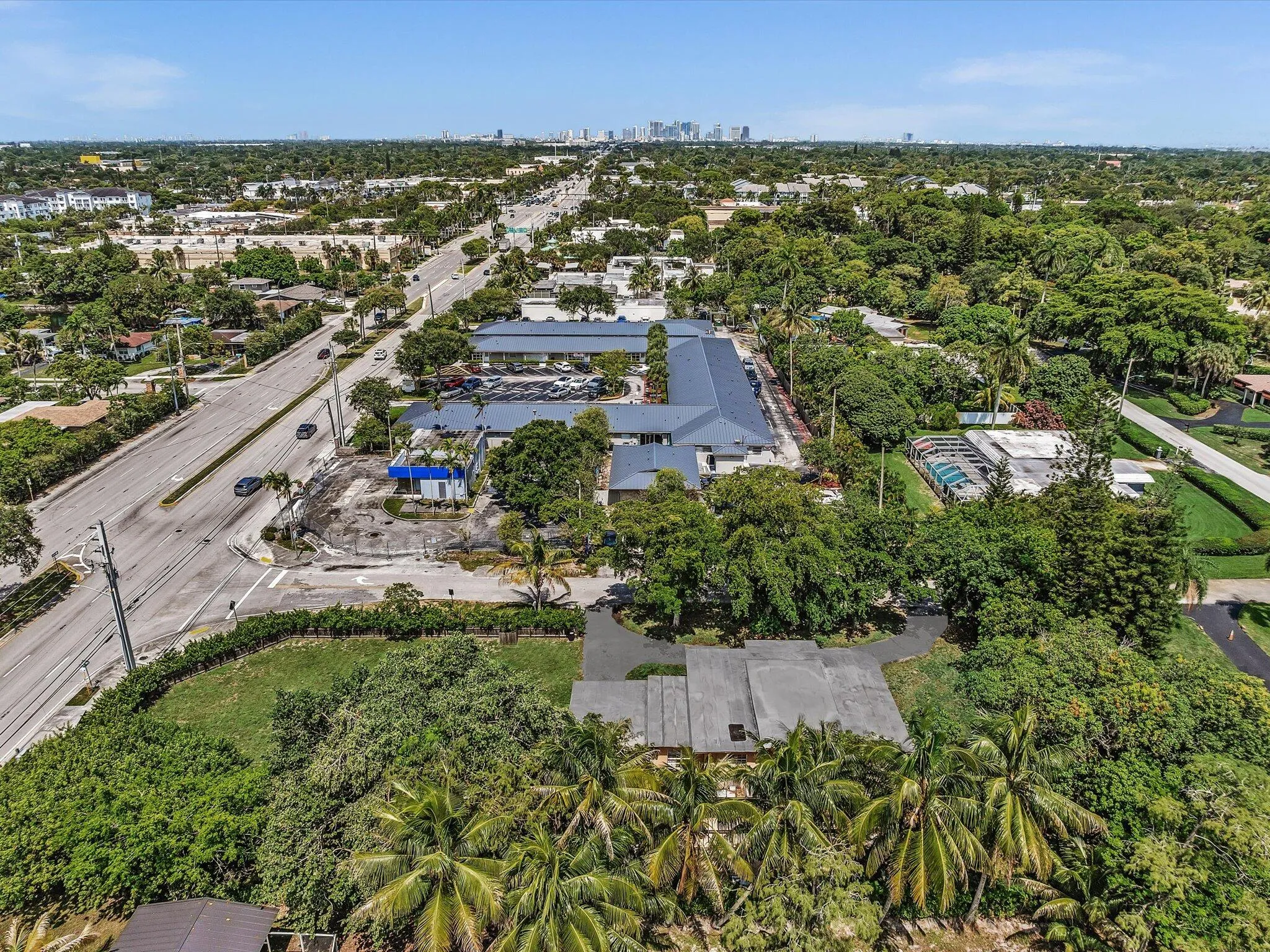 Aerial perspective showcasing a sprawling property with lush, mature landscaping and a generously sized paved driveway