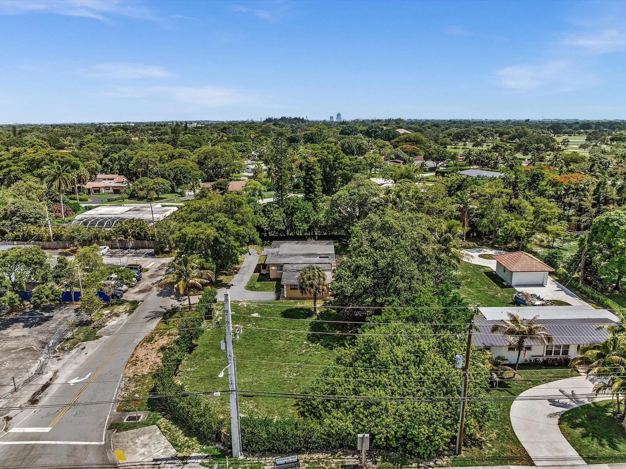 Expansive parcel featuring a main residence and detached garage, surrounded by mature trees and lush landscaping