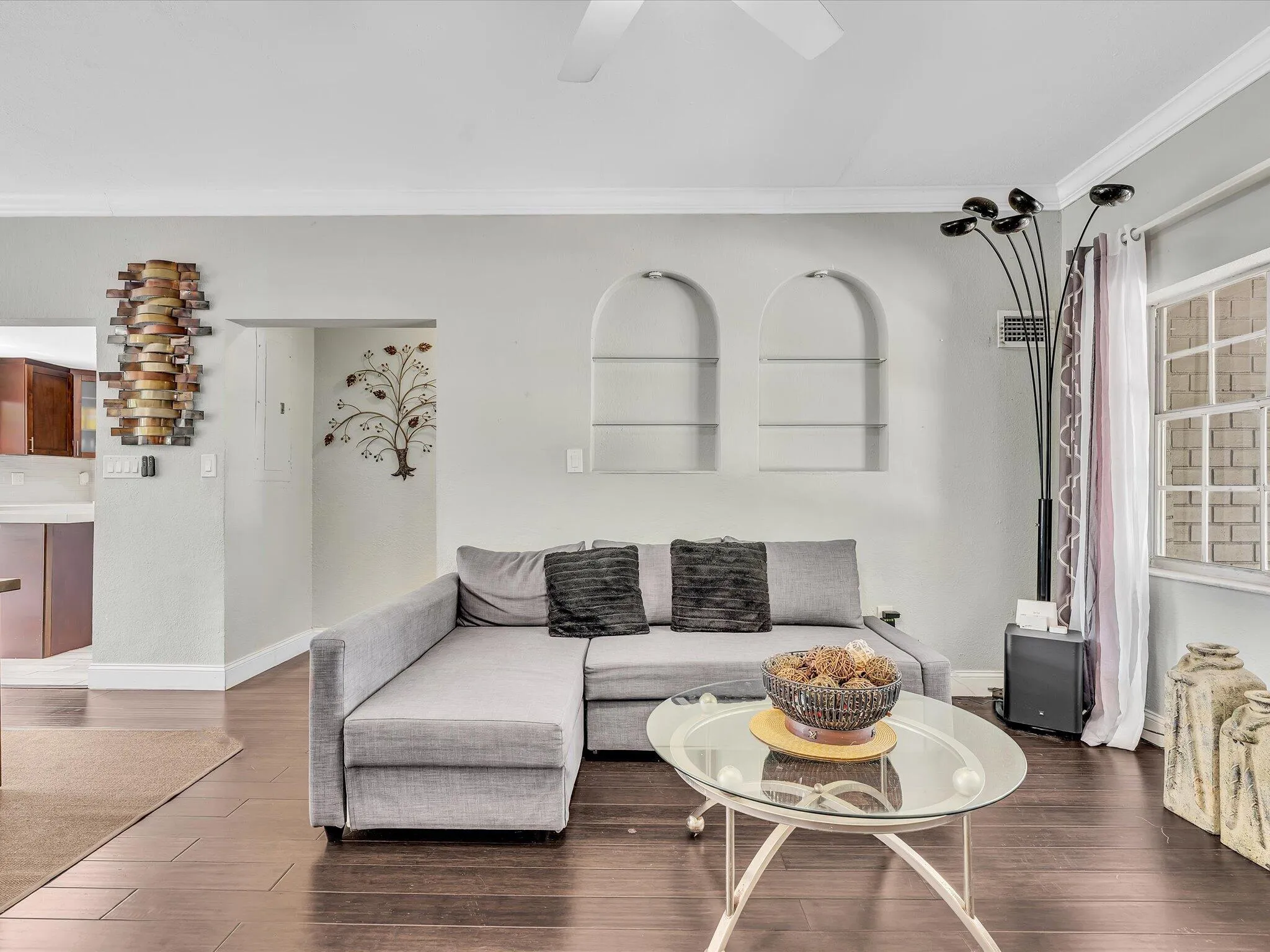 Living area featuring dark wood-finish flooring, light gray wall paint, and white crown molding