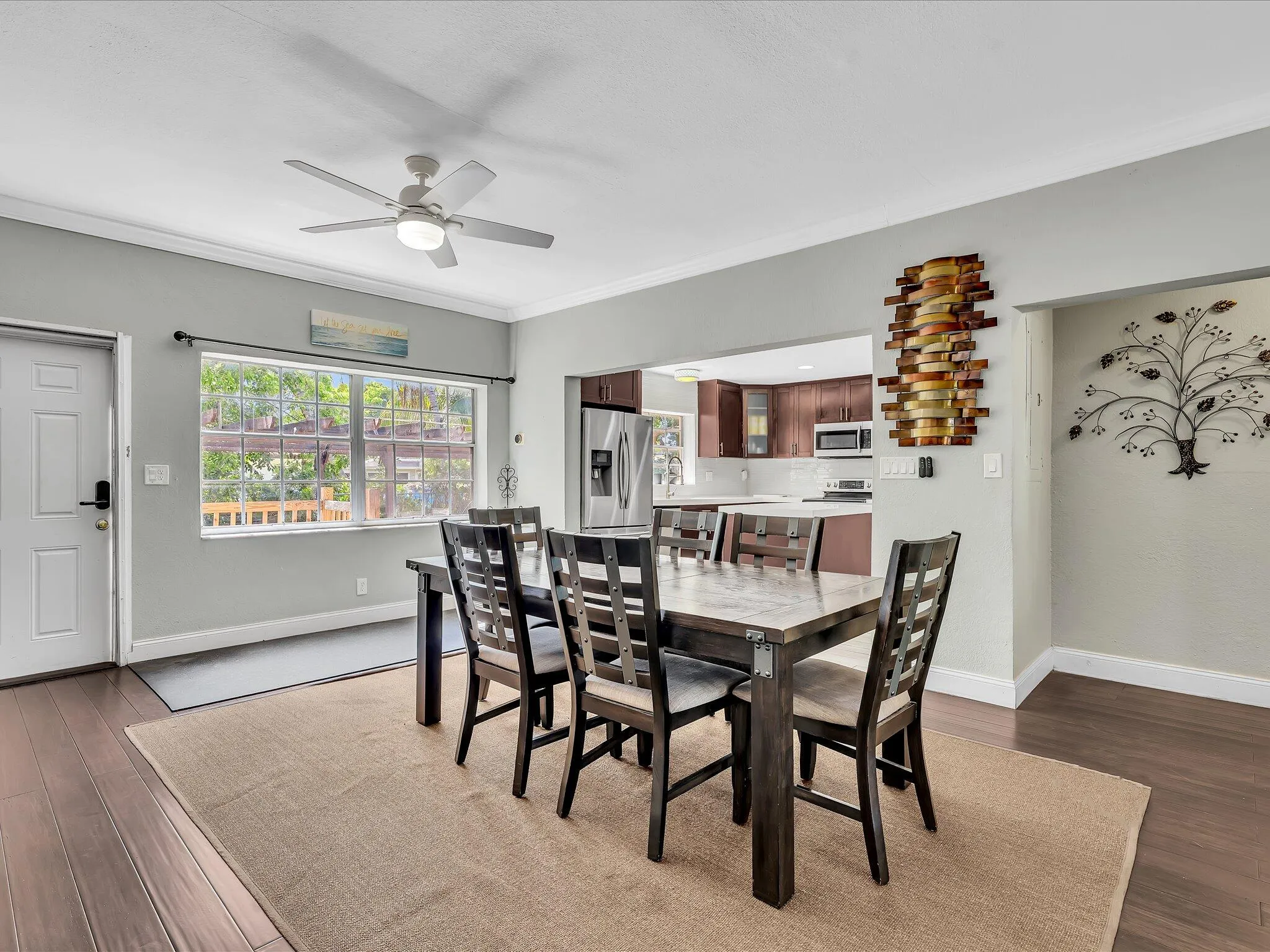 Open-concept dining area featuring wood-finish flooring and a ceiling fan