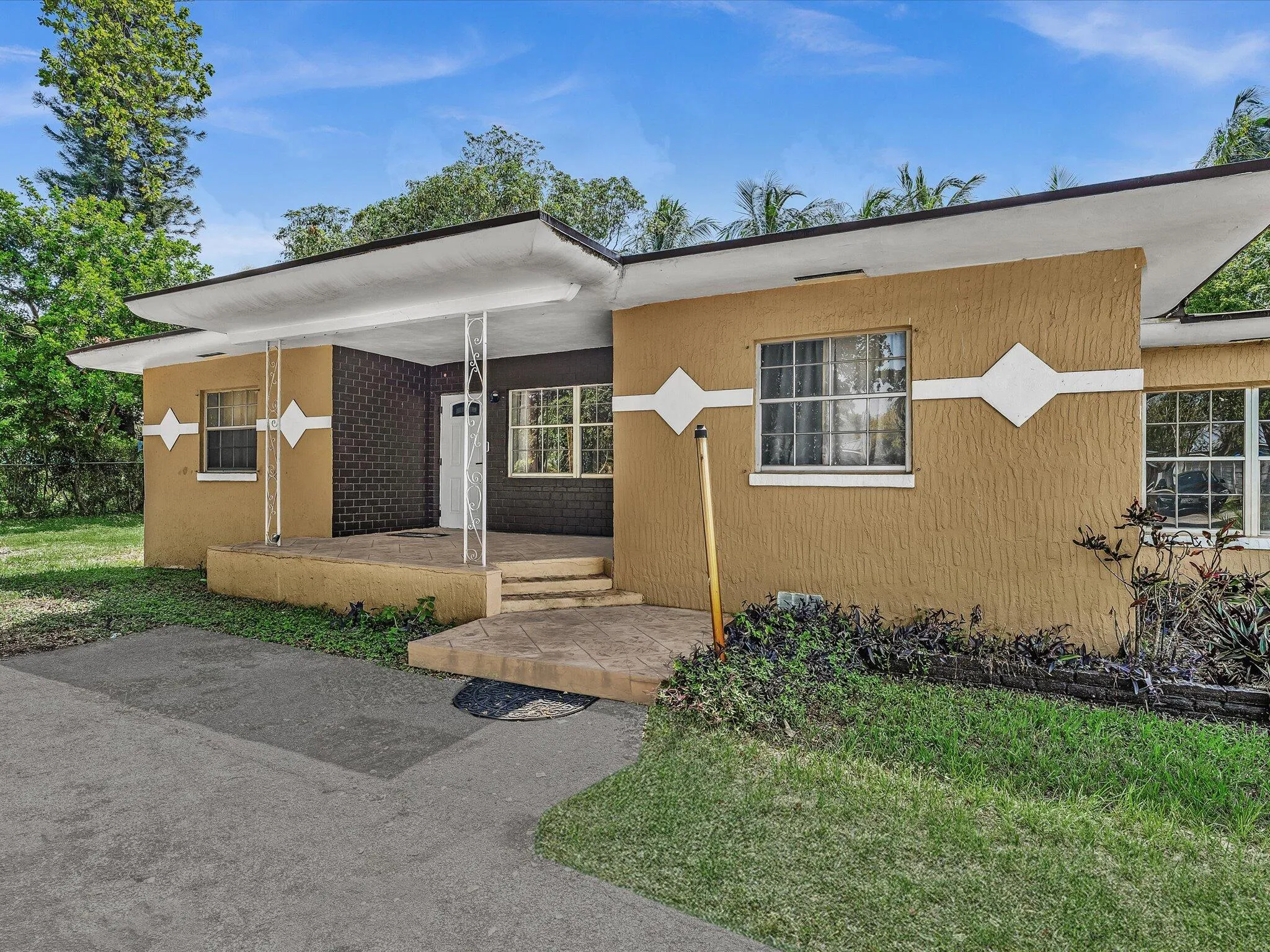 Architectural residence featuring a flat roofline, stucco exterior, and decorative diamond accents