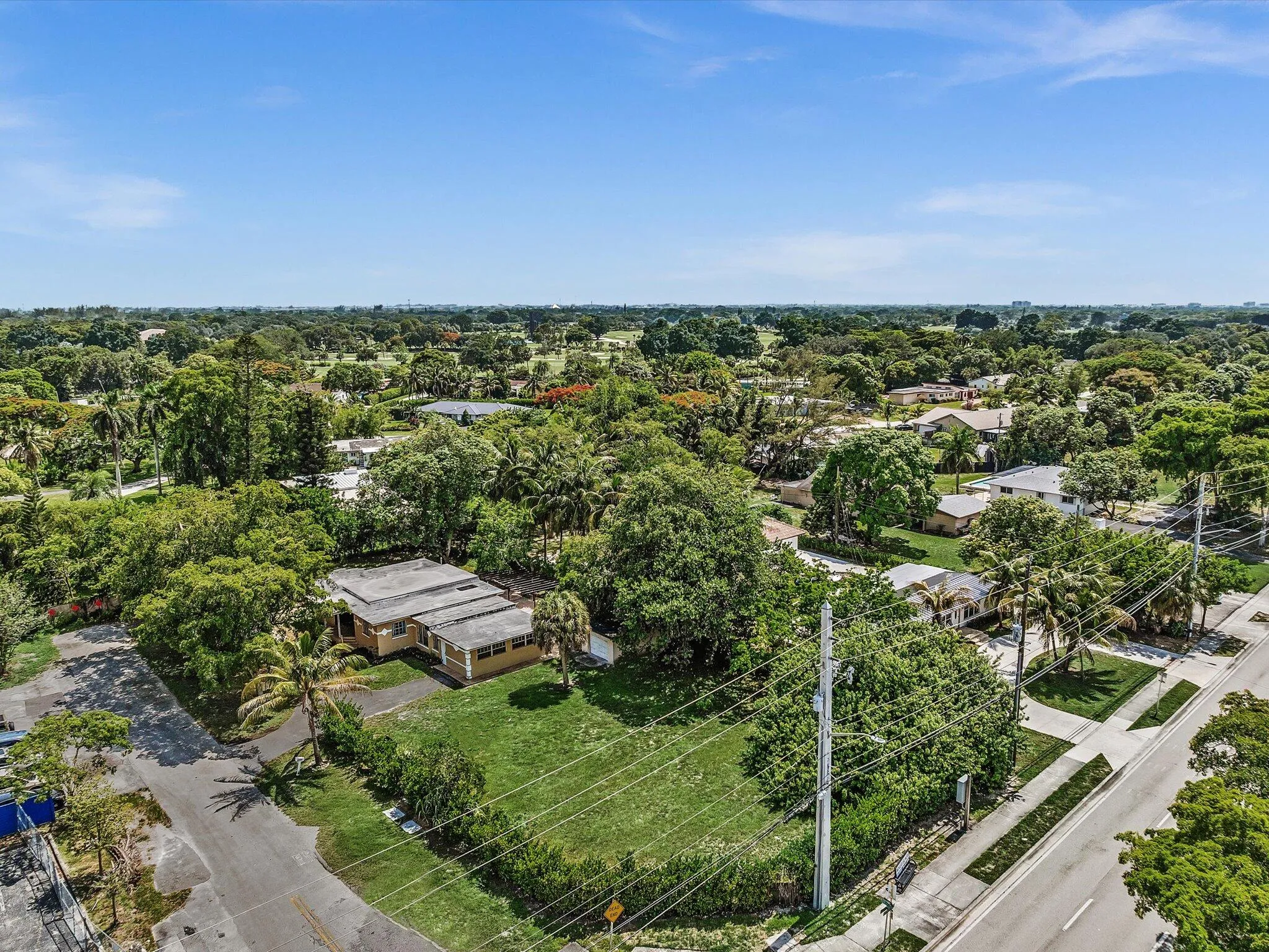 Expansive residential parcel featuring a single-story structure and verdant landscaping