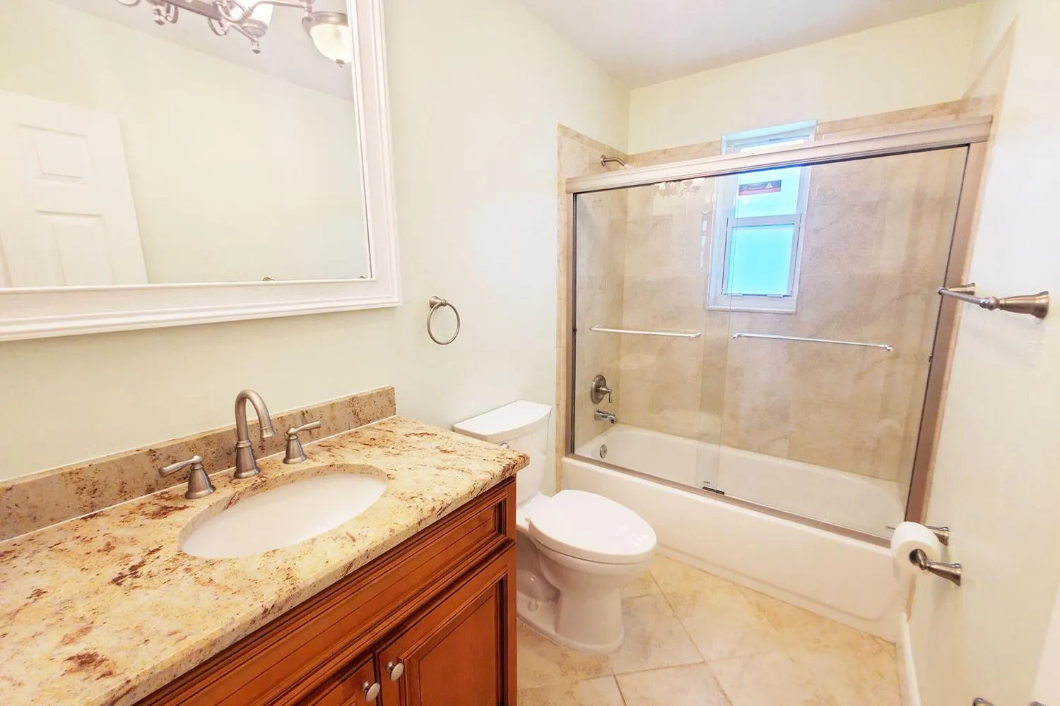 Bathroom featuring a warm-toned vanity with a stone countertop and undermount sink
