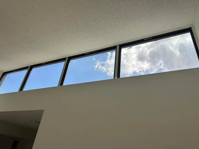 High transom windows with dark frames and a textured ceiling