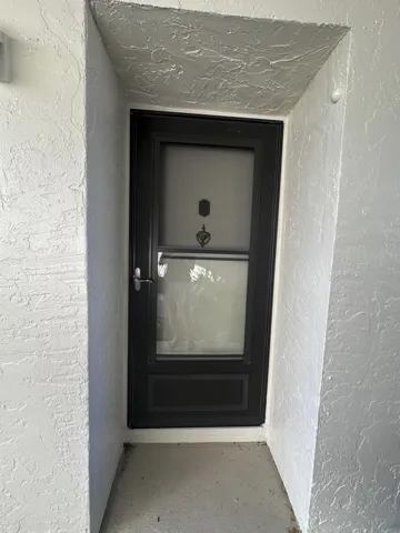 Black storm door with a decorative knocker