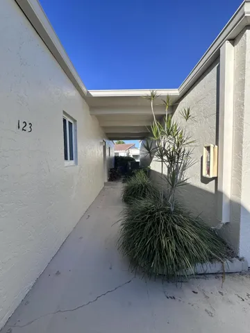 White stucco exterior with a prominent numerical address "123" and an exterior window