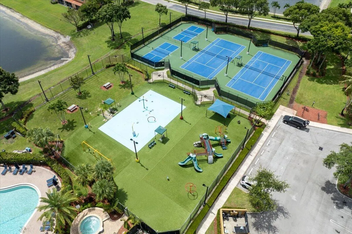 Recreational complex featuring multiple tennis courts, pickleball courts, a splash pad, and a playground