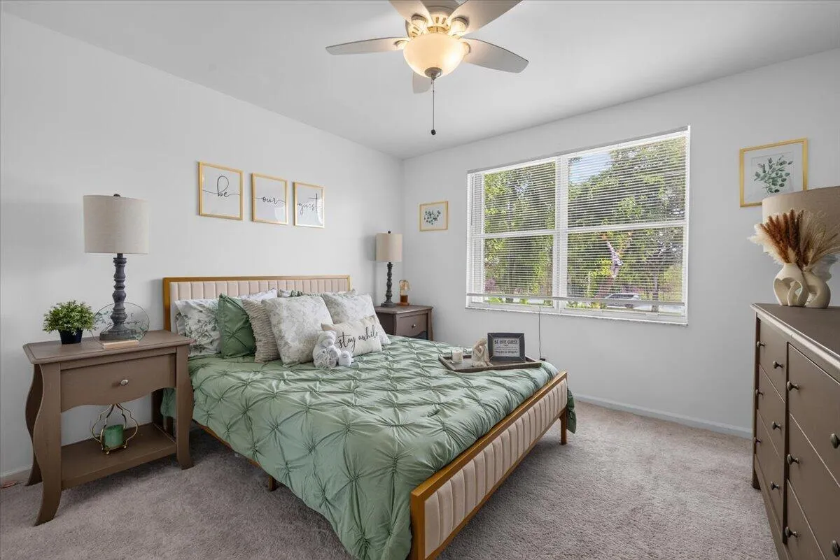 Carpeted room featuring a white ceiling and walls, a window with horizontal blinds, and a built-in ceiling fan with integrated lighting