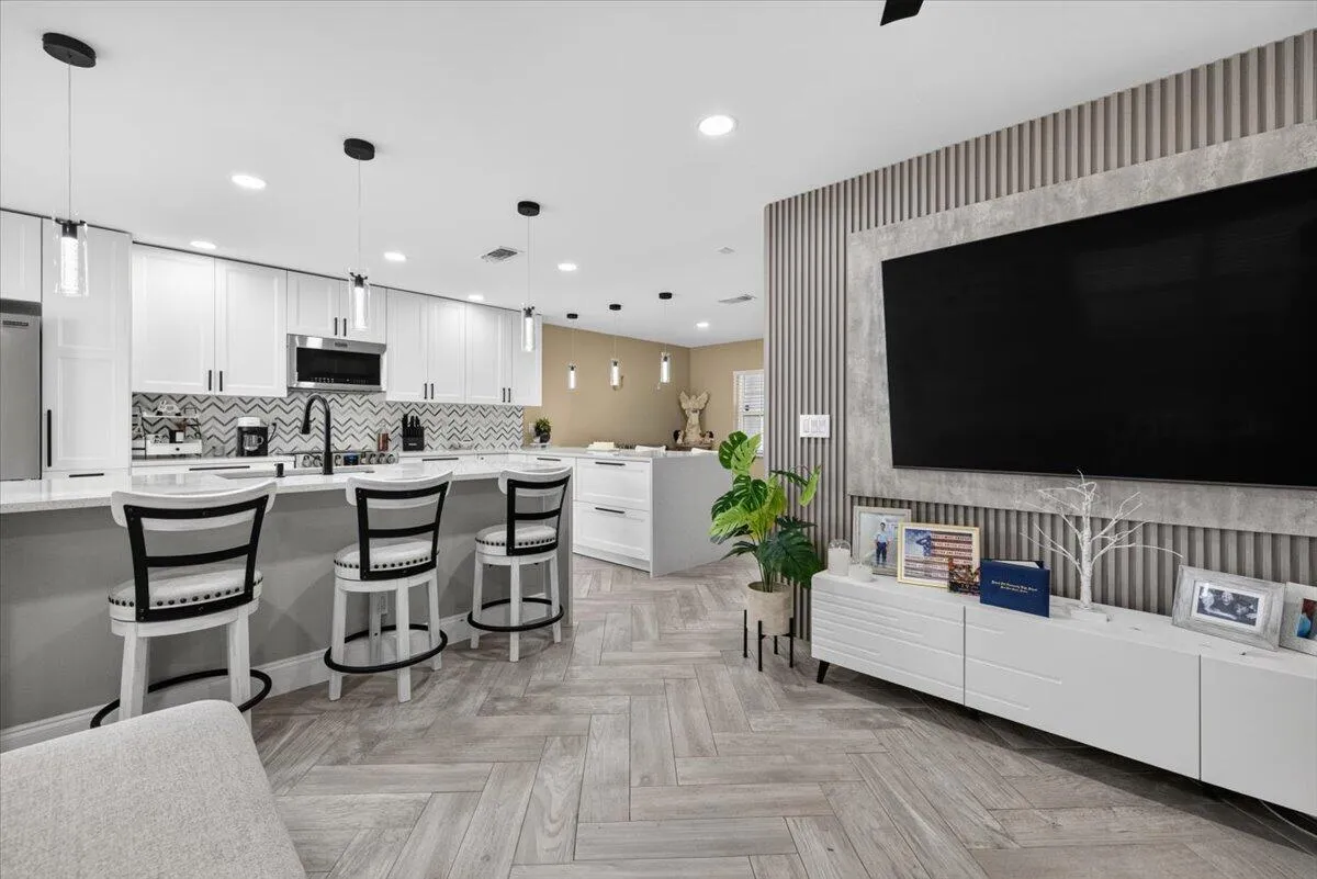 Open-concept living space featuring wood-finish herringbone flooring