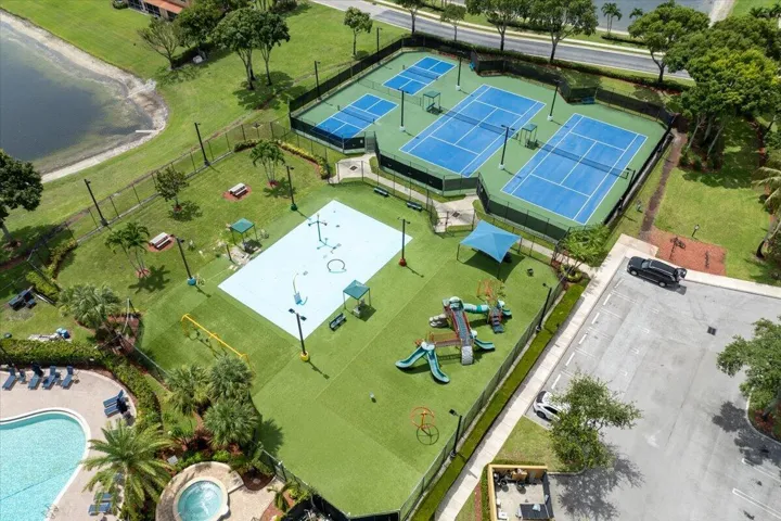 Recreational complex featuring multiple tennis courts, pickleball courts, a splash pad, and a playground