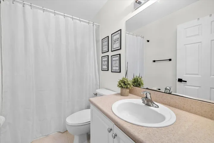 Bathroom vanity with an integrated sink, light-toned countertop, and chrome faucet
