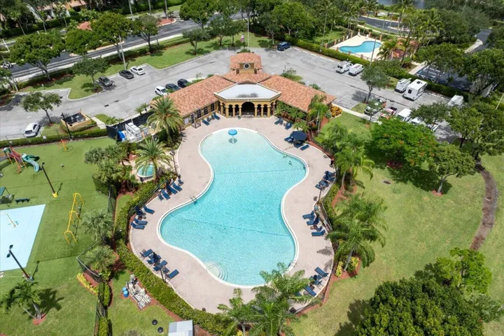 Expansive resort-style swimming pool featuring a freeform design, integrated spa, and surrounding lounge areas