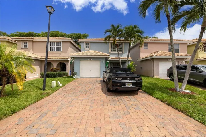 Property exterior featuring a paver driveway, single-car garage, and a light blue facade