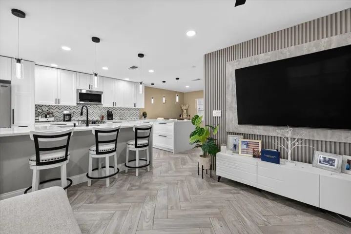 Open-concept living space featuring wood-finish herringbone flooring