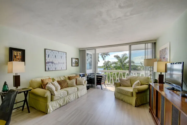 Spacious living area featuring light wood-finish flooring and direct access to an outdoor balcony