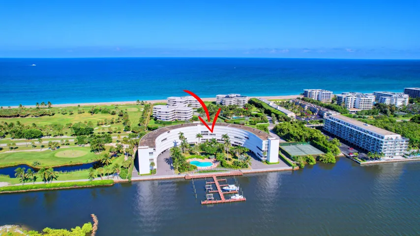 Curved architectural design with waterfront access, private boat dockage, and a swimming pool
