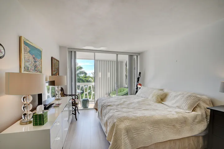 Bedroom featuring light wood-finish flooring, white walls, and a private balcony with sliding glass doors