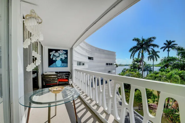 Spacious private balcony with a unique patterned railing and a glass-top table