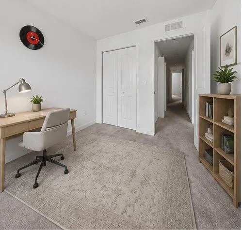 Light-toned wall-to-wall carpeting throughout this versatile room