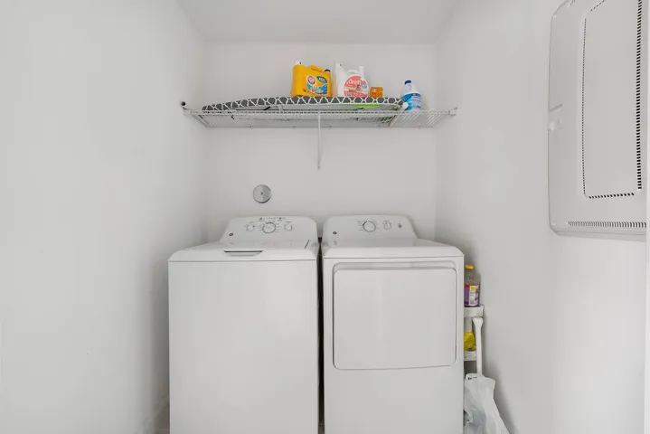 Dedicated laundry area featuring a white top-load washing machine and a white front-load dryer