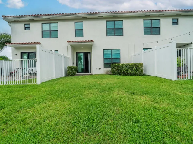 Private grassy area featuring partially white privacy fenced yard separating neighboring patios
