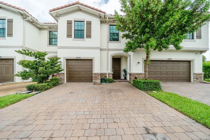 Mediterranean-inspired exterior with stucco finish, tile roof, and private driveway