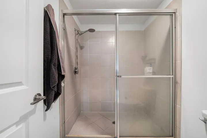 Enclosed shower with sliding glass doors and brushed nickel hardware
