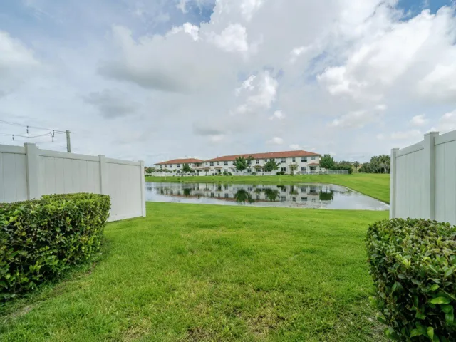 Private green lawn with waterview and partially white privacy fenced yard