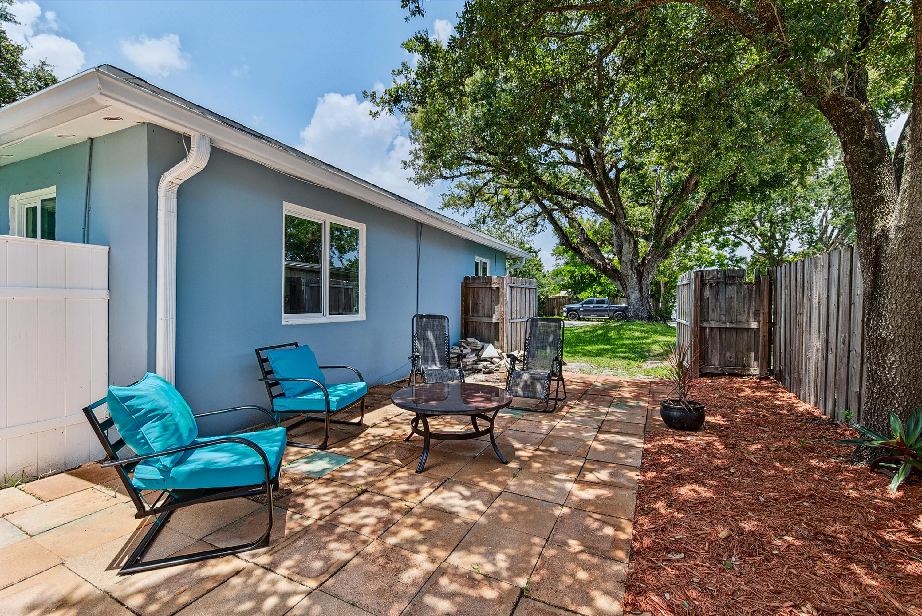 Side of home and side patio with gate opened