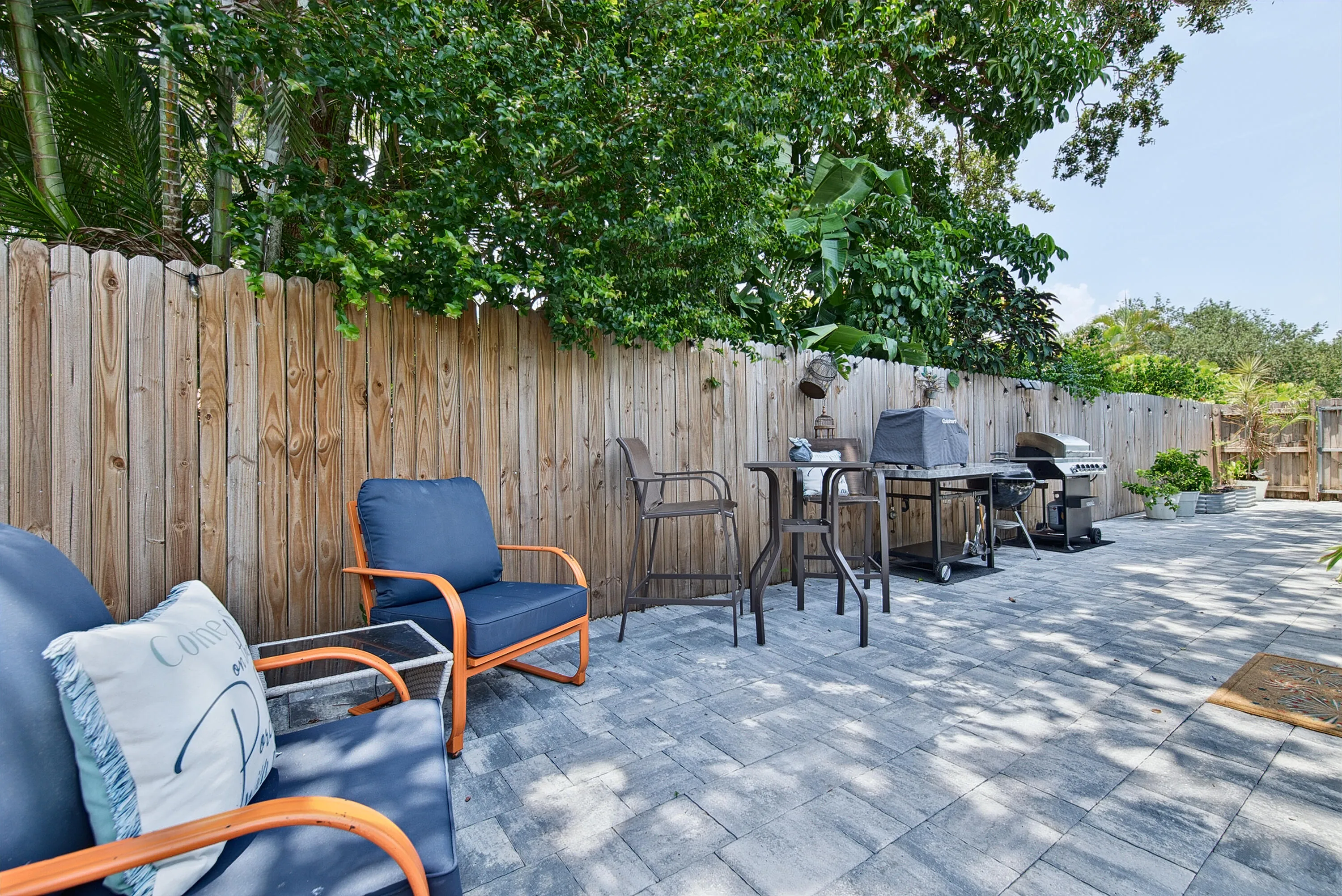 Spacious back patio with pavers and bbq grill and area