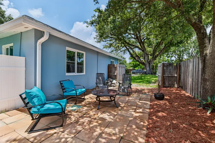 Side of home and side patio with gate opened