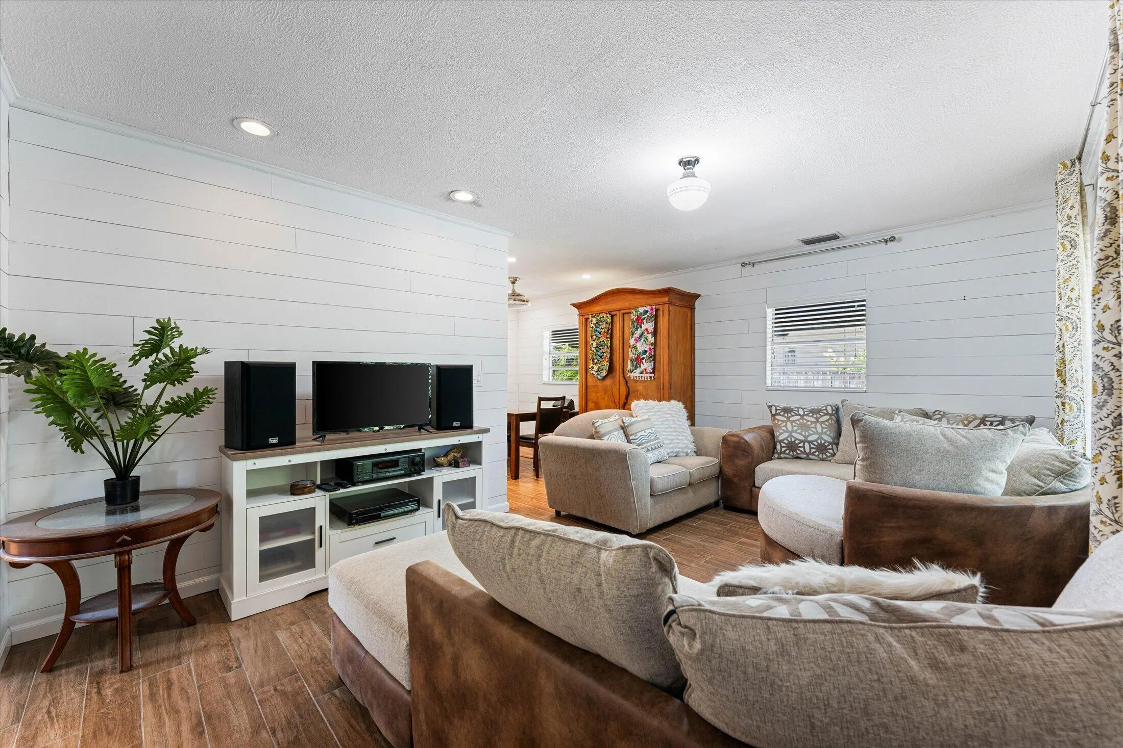 Living area featuring shiplap accent walls and wood-finish flooring